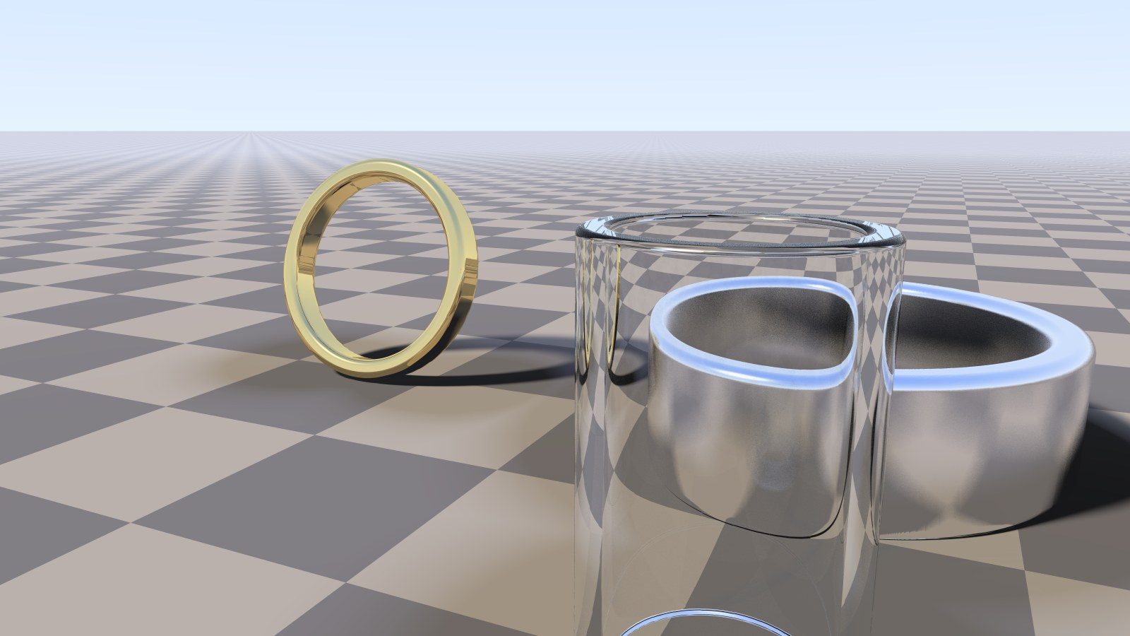 A gold ring, a satin chrome bracelet and a glass tube